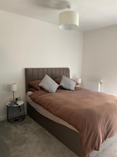 ein Schlafzimmer mit einem großen Bett mit einer braunen Decke in der Unterkunft Brand New Stunning 2-Bed Apartment in Dagenham in Dagenham