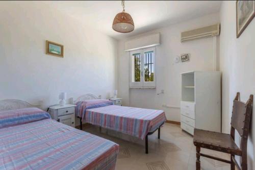- une chambre avec 2 lits, une commode et une fenêtre dans l'établissement Villa Serenità Vintage Charm a Lido Marini, à Lido Marini