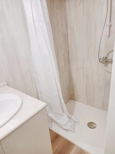 baño blanco con ducha y lavamanos en Bungalow de 3 chambres avec jardin et wifi a Montils, en Montils