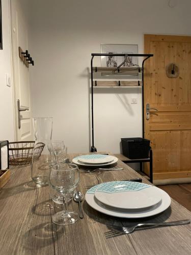 une table en bois avec des assiettes et des verres à vin dessus dans l'établissement Chez Jean-Yves et Zoé - LA BOHÈME - Au calme, Très propre, Proche parkings, à Niort