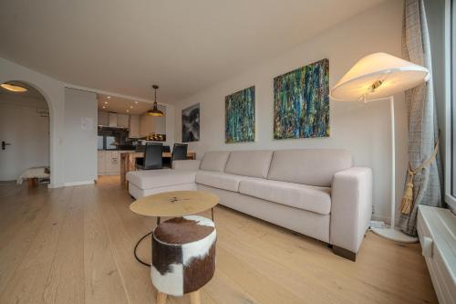 a living room with a white couch and a table at Galerie Obersee 4C in Arosa