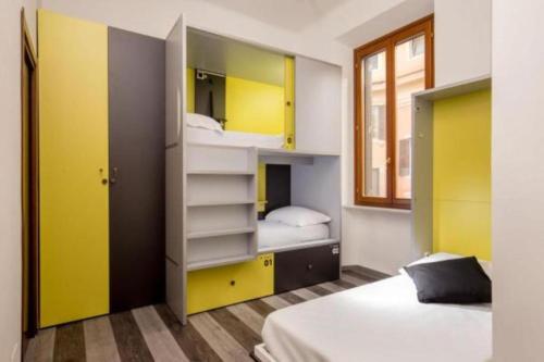 a bedroom with two bunk beds with yellow cabinets at Free Hostels Roma in Rome