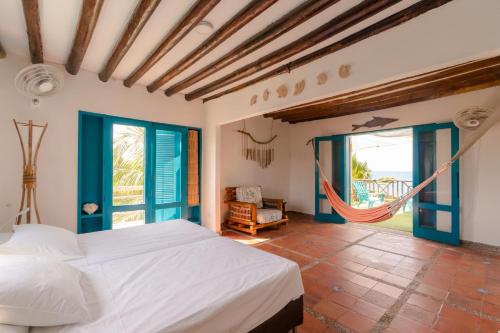 a bedroom with a bed and a hammock at Casa Tinti in Tintipan Island