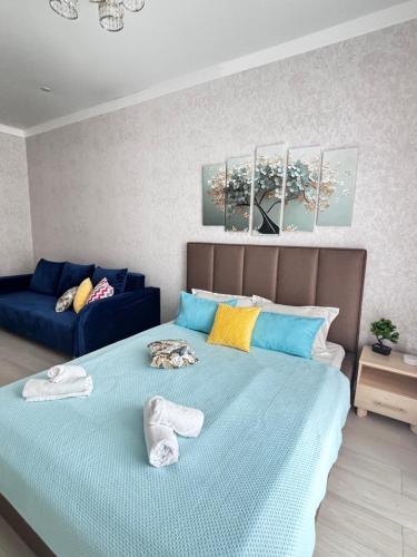 1 dormitorio con 1 cama con toallas en ЖК ALPAMYS, en Astana