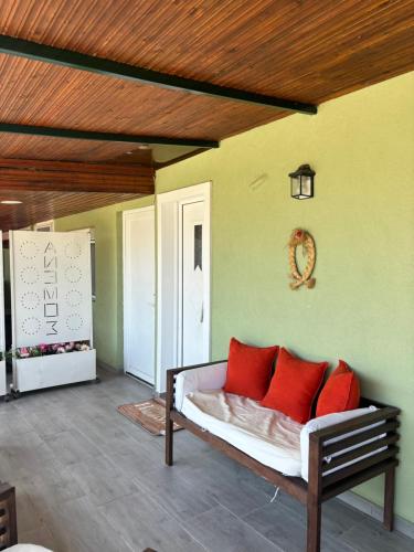a room with a couch with red pillows on it at Άνεμος Home in Elaiokhórion
