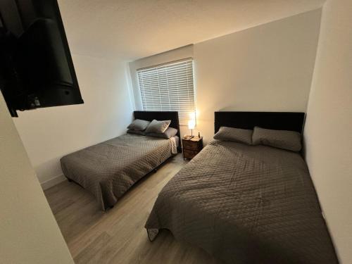 een slaapkamer met 2 bedden en een flatscreen-tv bij apartamento en kendall Miami in Miami