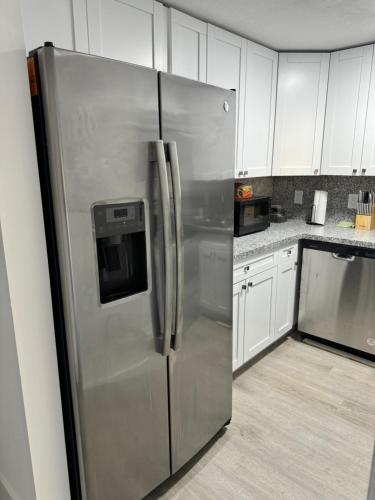 a stainless steel refrigerator in a kitchen with white cabinets at Apartamento en kendall Miami 2 Habitaciones y 3 baños in Miami