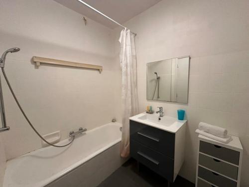 La salle de bains blanche est pourvue d'un lavabo, d'une baignoire et d'un lavabo. dans l'établissement C062 Appart fonctionne Proche du centre Cannes, à Cannes