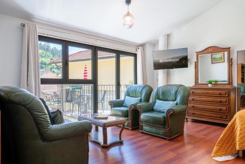 a living room with two chairs and a tv at Casa da Fonte de Pedra in Vieira do Minho