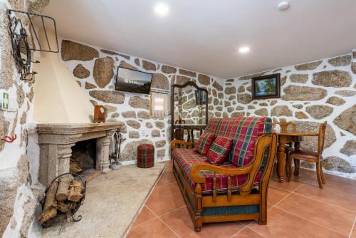 a living room with a stone wall at Casa da Fonte de Pedra in Vieira do Minho