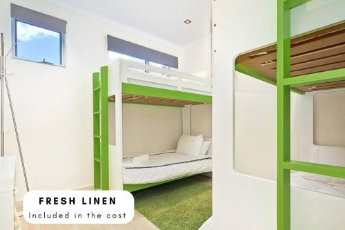 um quarto com um beliche e uma escada verde em Block Escape - Ocean View Apartment No 1 em Victor Harbor