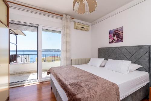 um quarto com uma cama e uma grande janela em Apartments Villa Ivanka em Trogir