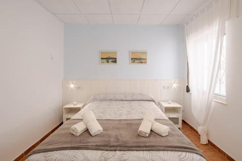 a bedroom with a large bed with two white tables at Apartamento playa del Carmen in Barbate