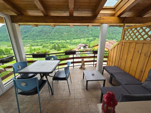 a porch with a table and chairs and a view at Apartments Denis in Tolmin