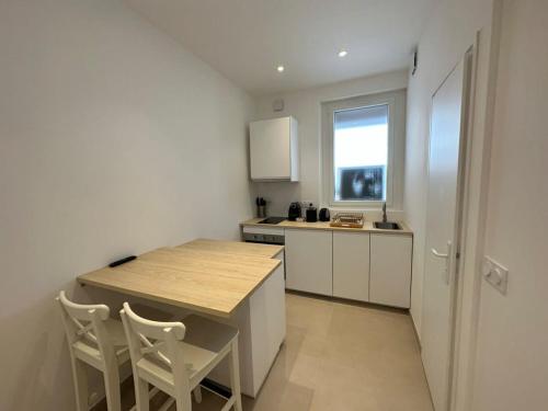 - une cuisine avec une table et des chaises en bois dans la chambre dans l'établissement C073-Studio neuf et lumineux au carre d'or Croisette, à Cannes