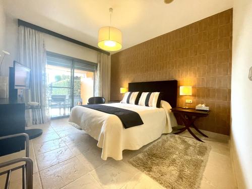 um quarto com uma cama grande e uma janela grande em Luxury 2-bed apt in Benatalaya em Estepona