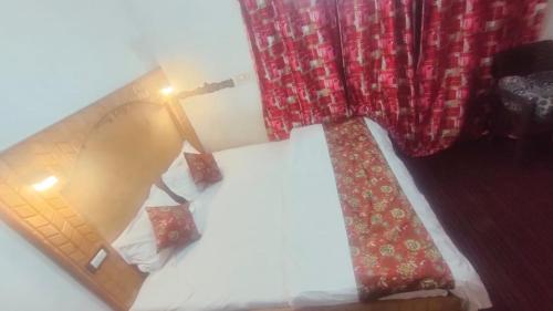 um quarto com uma cama com um candeeiro e cortinas em THE Q2 RESIDENCY em Srinagar