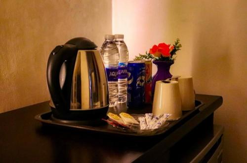 a table with a coffee maker and bottles of water at Royal Golden Pyramids Inn in Cairo