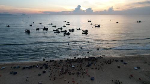 un gruppo di persone in acqua in spiaggia di Blue sea motel a Thăng Bình