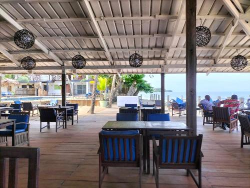 a restaurant with tables and chairs and a view of the ocean at Hôtel du Phare in Kribi
