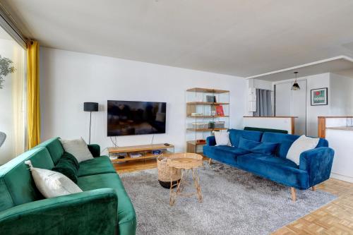een woonkamer met twee blauwe banken en een tafel bij 825 Suite Bacla - Superbe appartement in Courbevoie