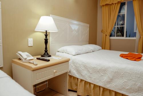 a hotel room with two beds and a telephone at Hotel Casona del Lago in Flores