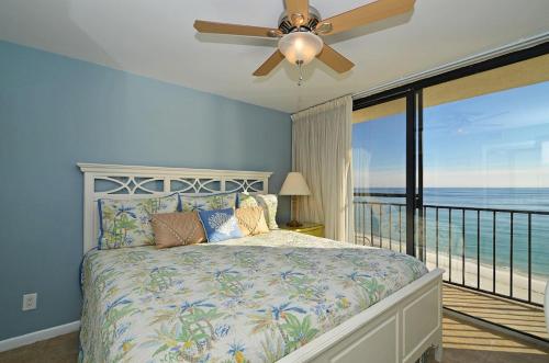 a bedroom with a bed with a ceiling fan and a balcony at One Seagrove Place 0908 in Santa Rosa Beach
