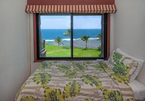 a bedroom with a bed with a view of the ocean at Sealodge F9 in Princeville