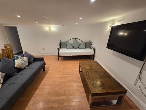 a living room with a couch and a flat screen tv at Wilsons Lodge in Blackpool