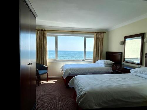 una camera d'albergo con due letti e vista sull'oceano di Regent Court - Seafront, Sandown - FREE CAR FERRY a Sandown