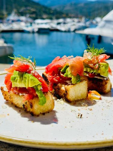 two pieces of food on a plate next to the water at Hotel Restaurant L'Europe in Saint-Florent
