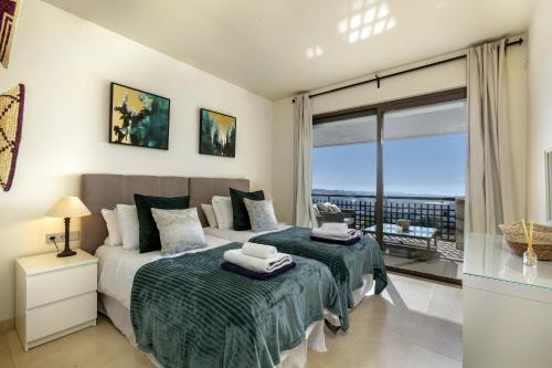 a bedroom with a bed and a large window at Tranquil 2-bed apt Alanda Flamingos in Estepona