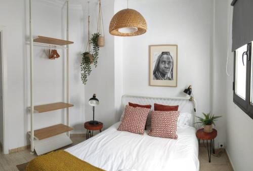 1 dormitorio con cama blanca y almohadas rojas en Beach apartment +3Bed +2Bath +Wifi, en Las Palmas de Gran Canaria
