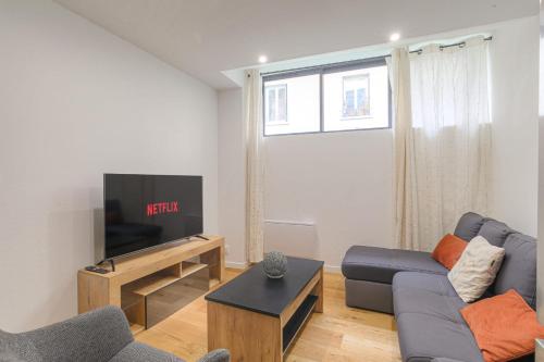 un salon avec un canapé et une télévision dans l'établissement Cosy et Charmant wifi très haut débit, à Lyon