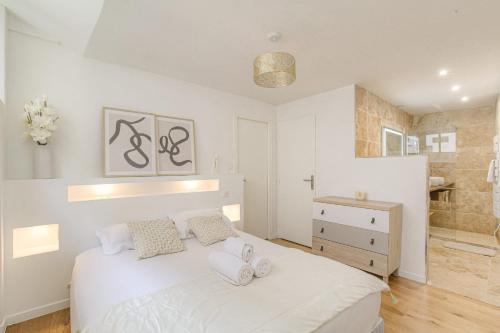 une chambre avec un lit blanc et une salle de bain dans l'établissement Cosy et Charmant wifi très haut débit, à Lyon