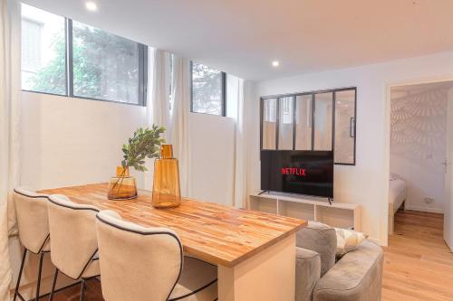 un salon avec une table et une télévision dans l'établissement Cosy et Chaleureux wifi très haut débit, à Lyon