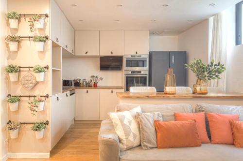 un salon avec un canapé et une cuisine dans l'établissement Cosy et Chaleureux wifi très haut débit, à Lyon