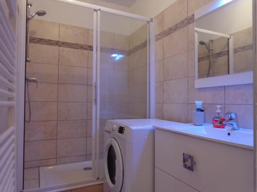 een badkamer met een wasmachine en een douche bij Appartement n° 32 in Barèges