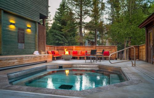 a swimming pool on a patio with a fire pit at Buffalo Mountain Lodge in Banff