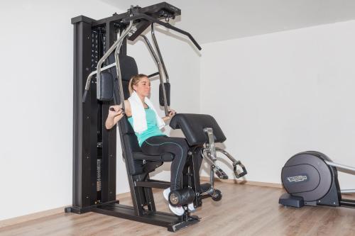 a woman is in a gym on a exercise bike at Hotel Europa in San Martino di Castrozza