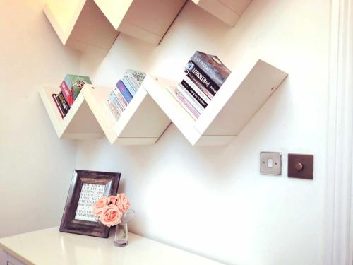 a room with a shelf with books on the wall at The Small Arms Factory in Enfield Lock
