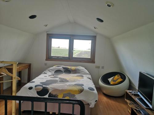 a small bedroom with a bed and a window at Sweet Tiny House in Westbeemster
