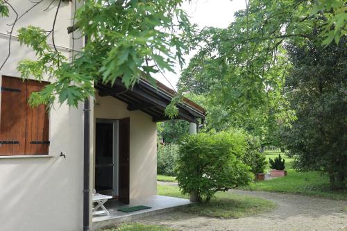 ein kleines weißes Gebäude mit einer Tür und einem Fenster in der Unterkunft Holiday Home Giaron in Rosolina