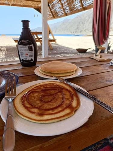 a table with two plates of pancakes on top of it at Sea sound Camp in Nuweiba‘ el Muzeinah