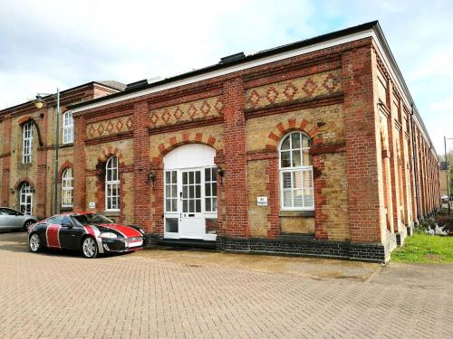 a red brick building with a car parked in front of it at The Small Arms Factory in Enfield Lock