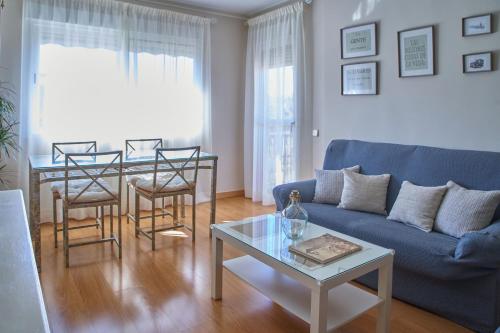 a living room with a blue couch and a table at Lux Buenavista in Toledo