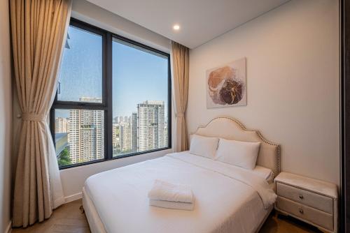 een slaapkamer met een wit bed en een groot raam bij Riverside Lumiere Luxury Vacation in Ho Chi Minh-stad