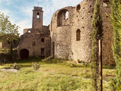 an old stone building with a tower in a field at Lover's Nest by Holiday World in Baiardo