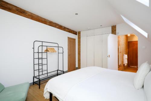 um quarto com uma cama branca e uma prateleira em Shard View near Borough Market em Londres