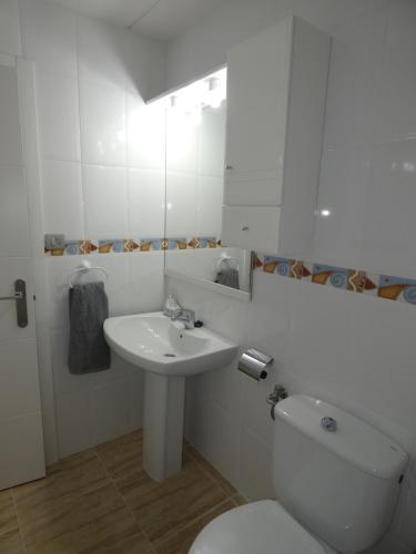 een witte badkamer met een toilet en een wastafel bij Vivienda en centro de Yecla in Yecla